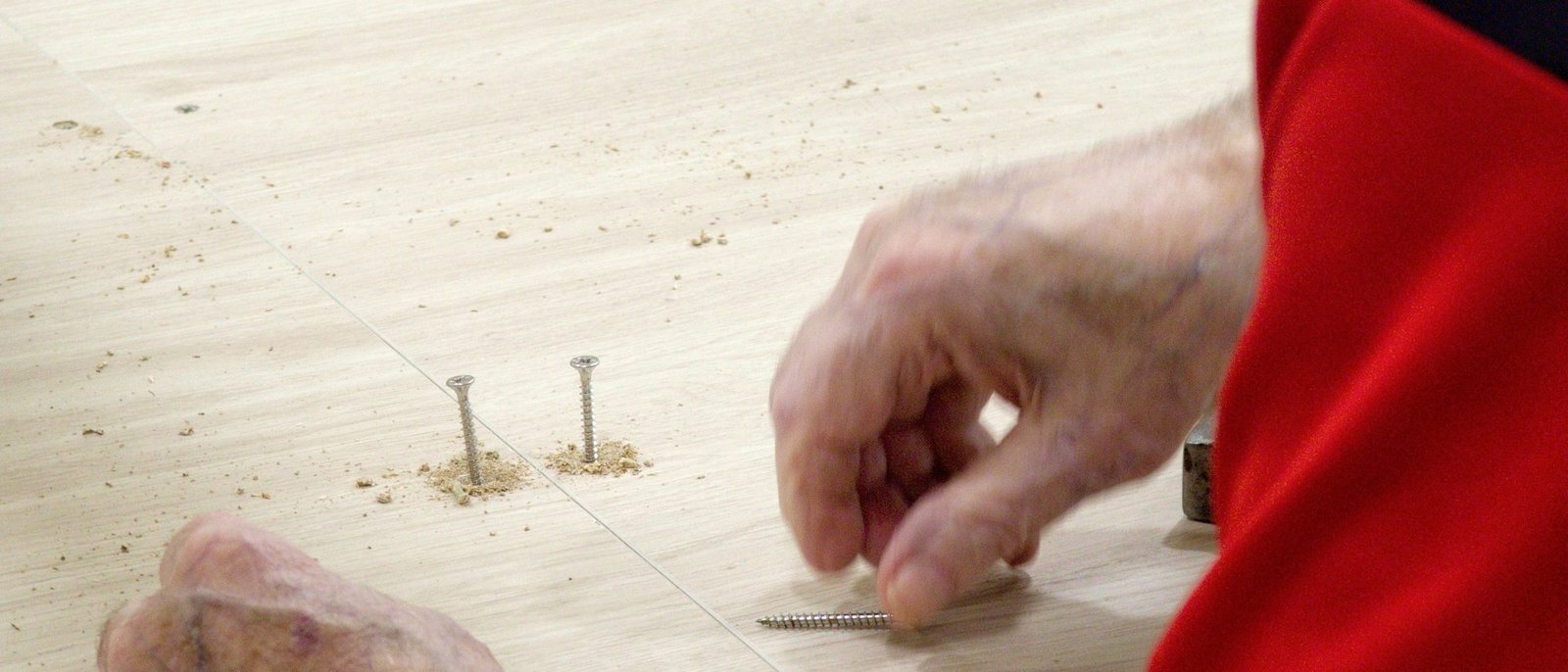 Mains d'artisan posant des clous sur un plateau
