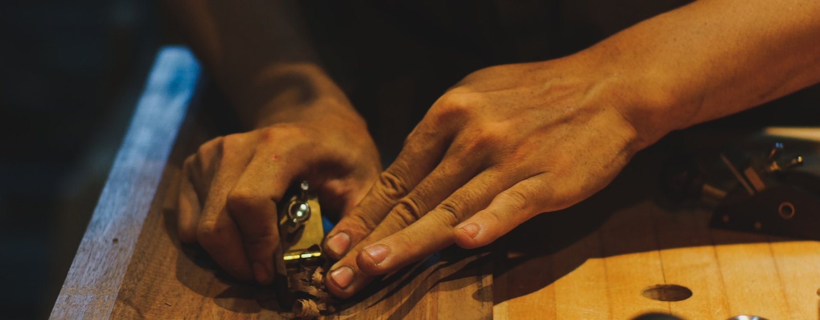 Menuisier façonnant une pièce de bois à la raboteuse à main